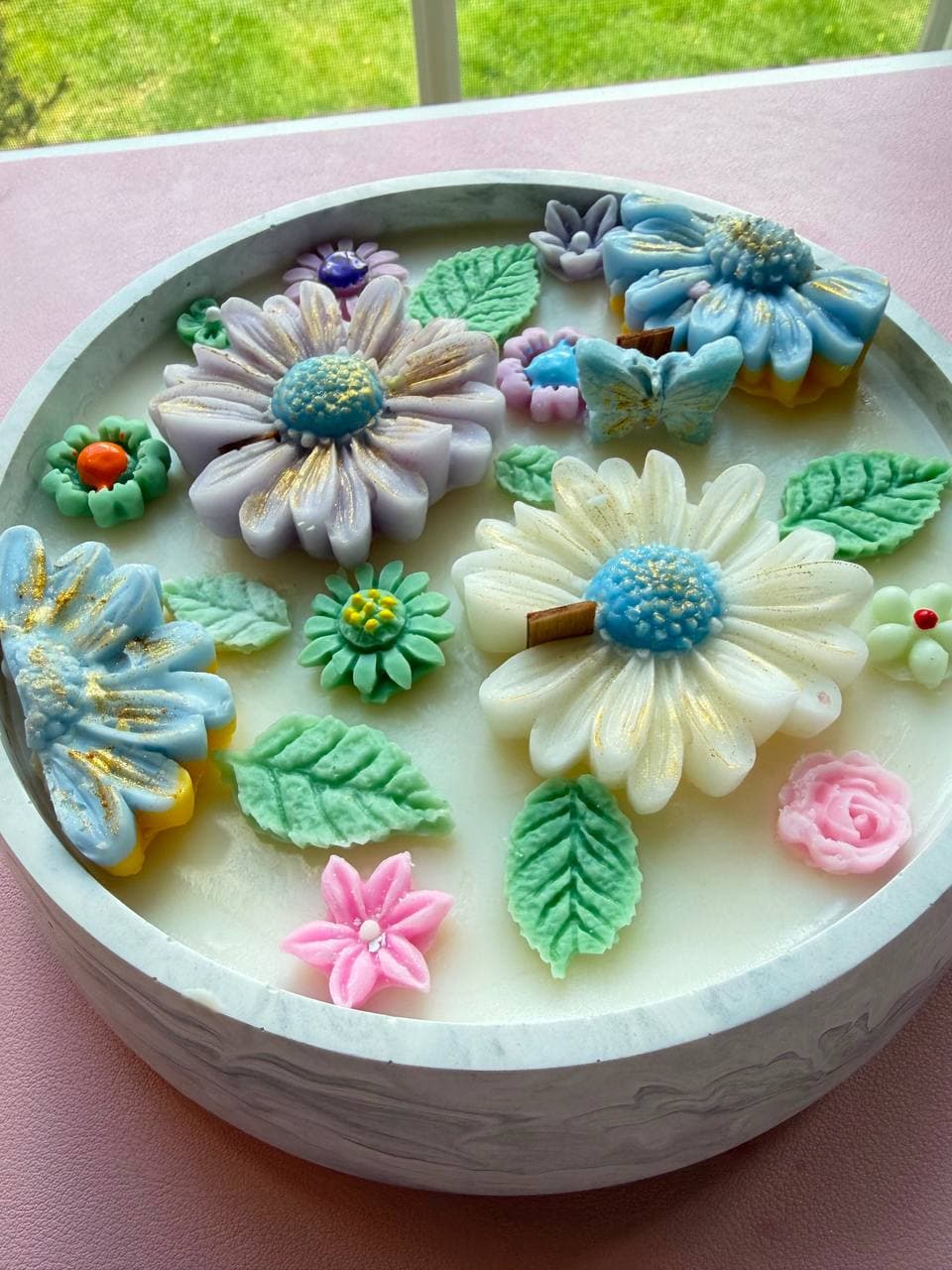 Bowl de concreto colmado de un jardín de flores de cera.